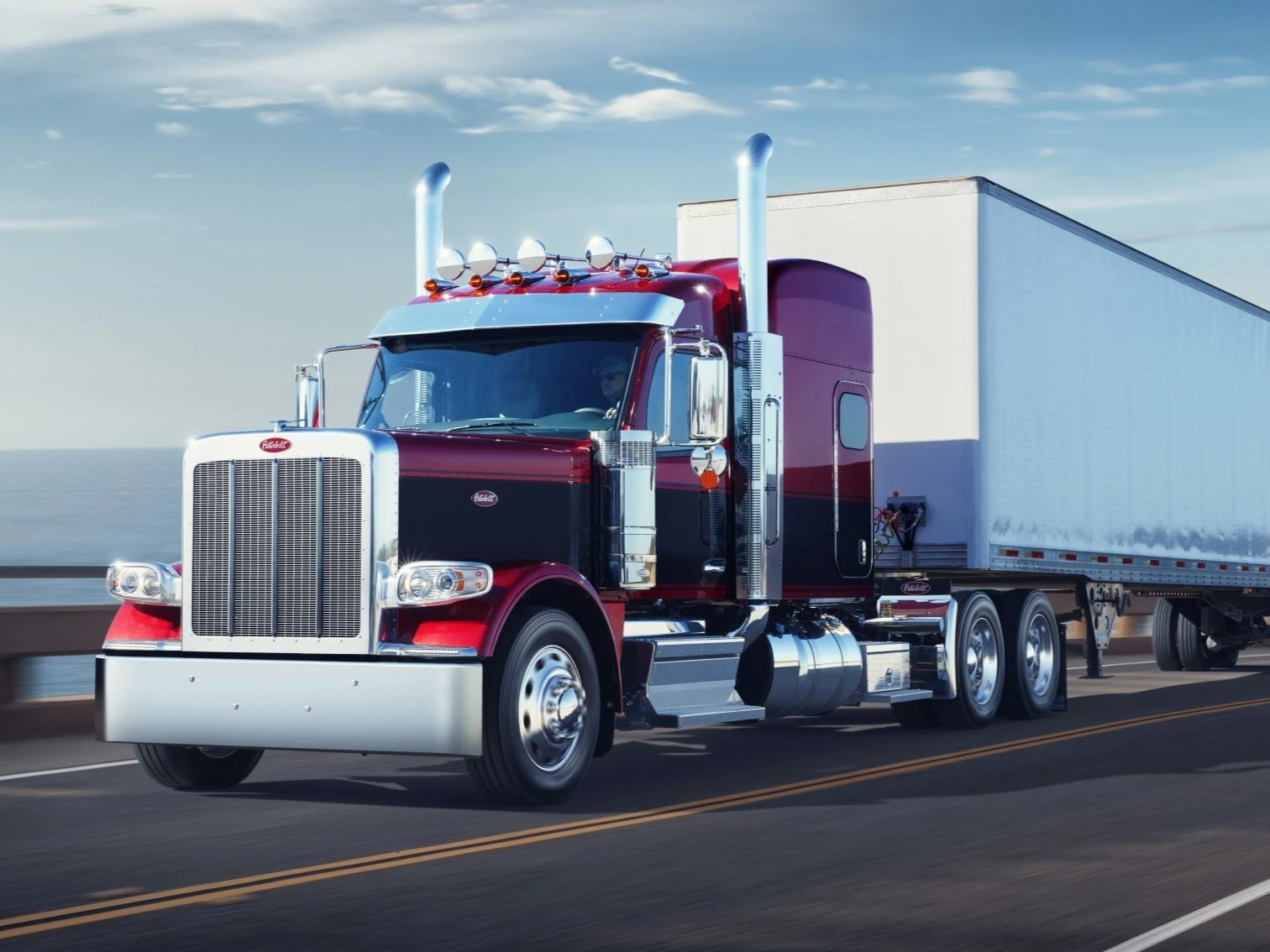 Peterbilt Model 589 Class 8 On-Highway sleeper tractor truck in red with black stripe and white trailer.