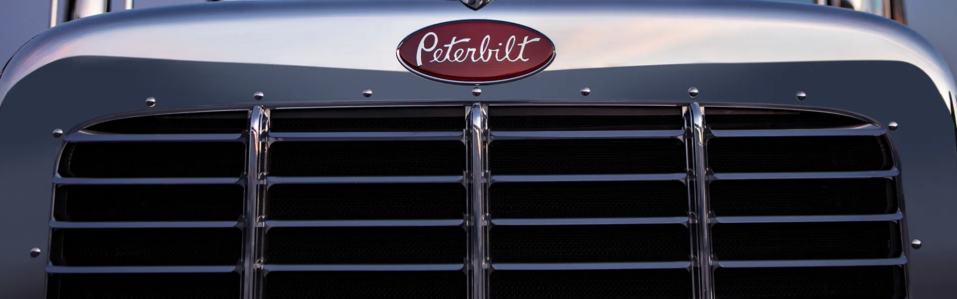 Banner Background - In 2006, the famous Peterbilt Model 389 proudly took its role as the torch bearer for Peterbilt’s iconic legacy of power, capability, luxury and style. Known as one of the most powerful tractors on the road, Model 389 amassed a community of devoted fans and admirers like no other truck before it. More than 100,000 Model 389 trucks were manufactured during its 18-year production run. Today, the truck still maintains its influential presence in the trucking world and beyond.